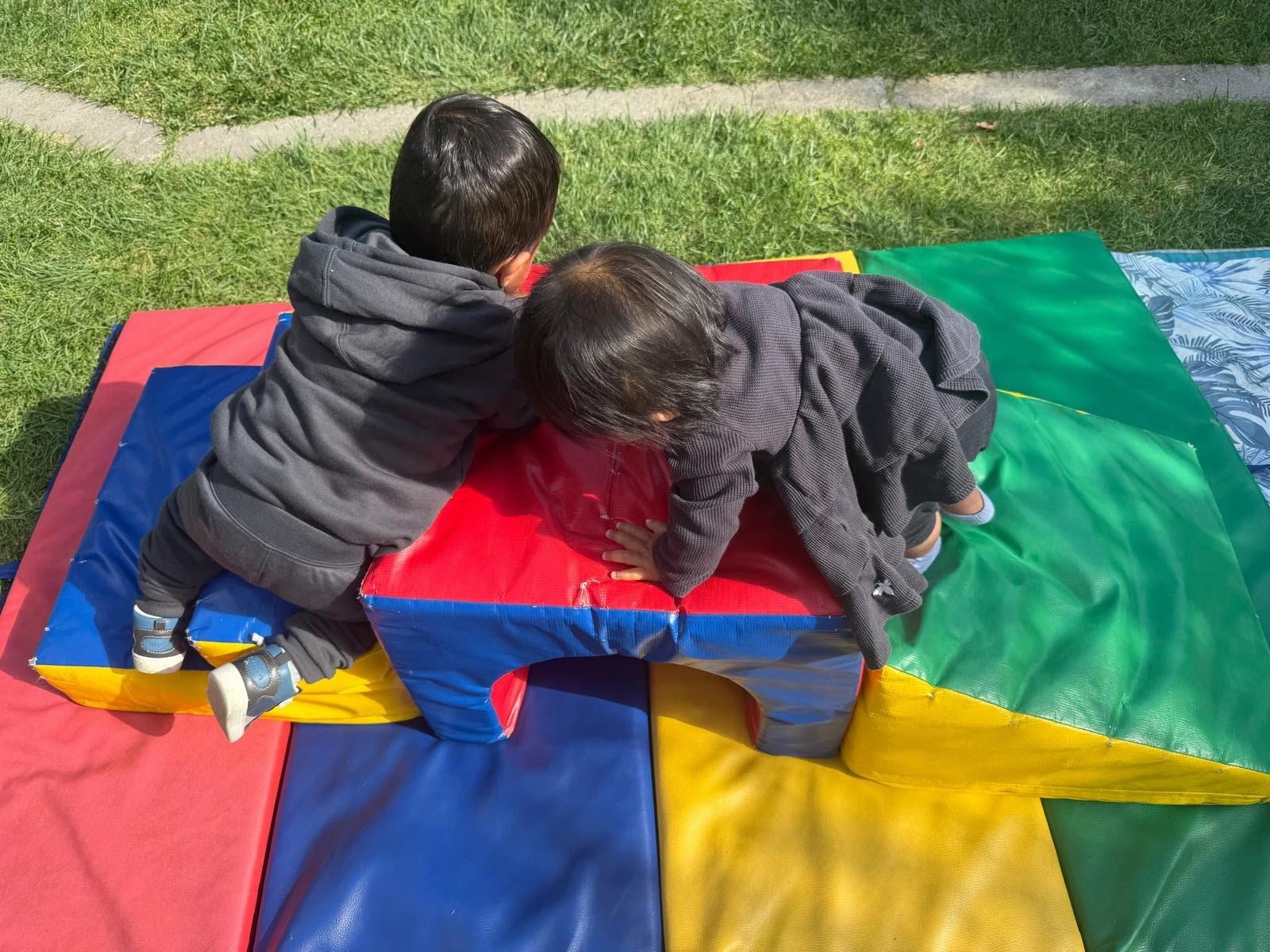 Children playing together with colorful soft climbing blocks